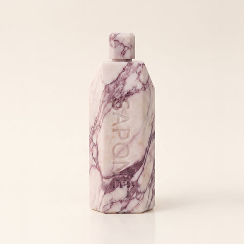 Marble Conditioner, an upright block of cream and plum veined marble with a hexagonal cap and SAPONE engraved down the front