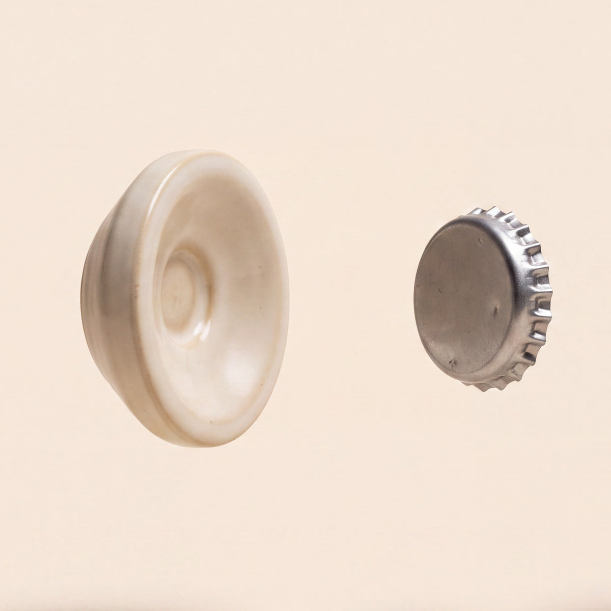 The Magnetic Soap Holder, a cream ceramic disc shown with a small metal disc